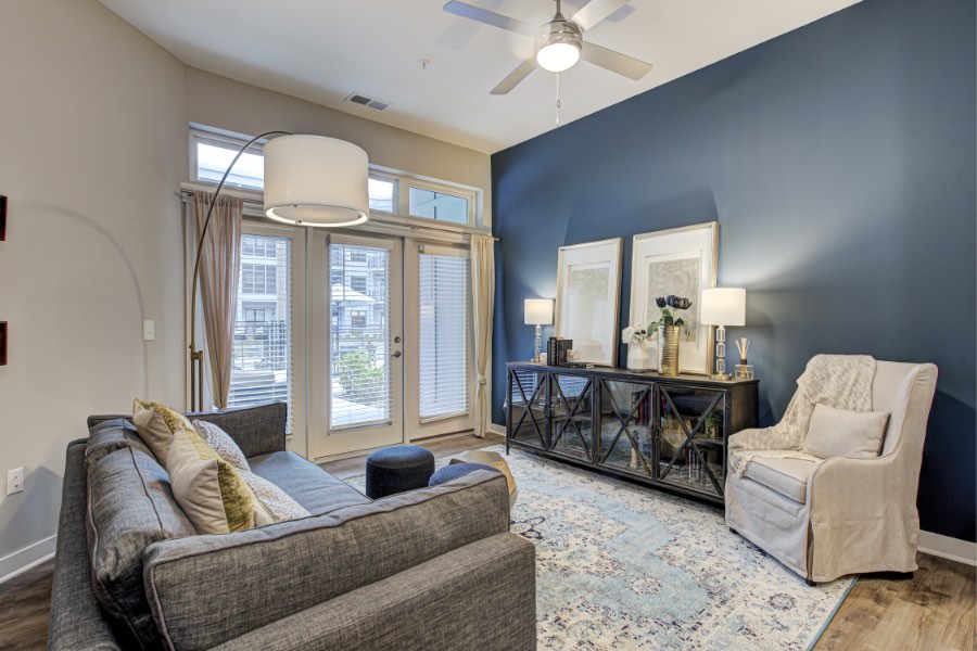 An apartment locator will help you find the perfect place like this lovely unit at Midtown Flats. Apartment living room with area rug and view to the exterior.